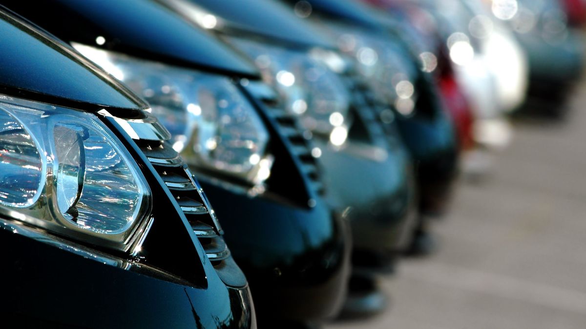 A line of cars at a dealership, showing only their front