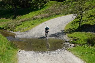 Anna Abram cycling over a ford along the Trans Cambrian Way