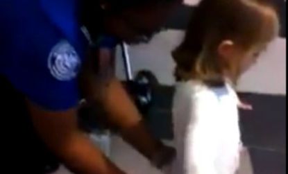 A TSA worker frisks a 6-year-old at New Orleans' international airport earlier this month.