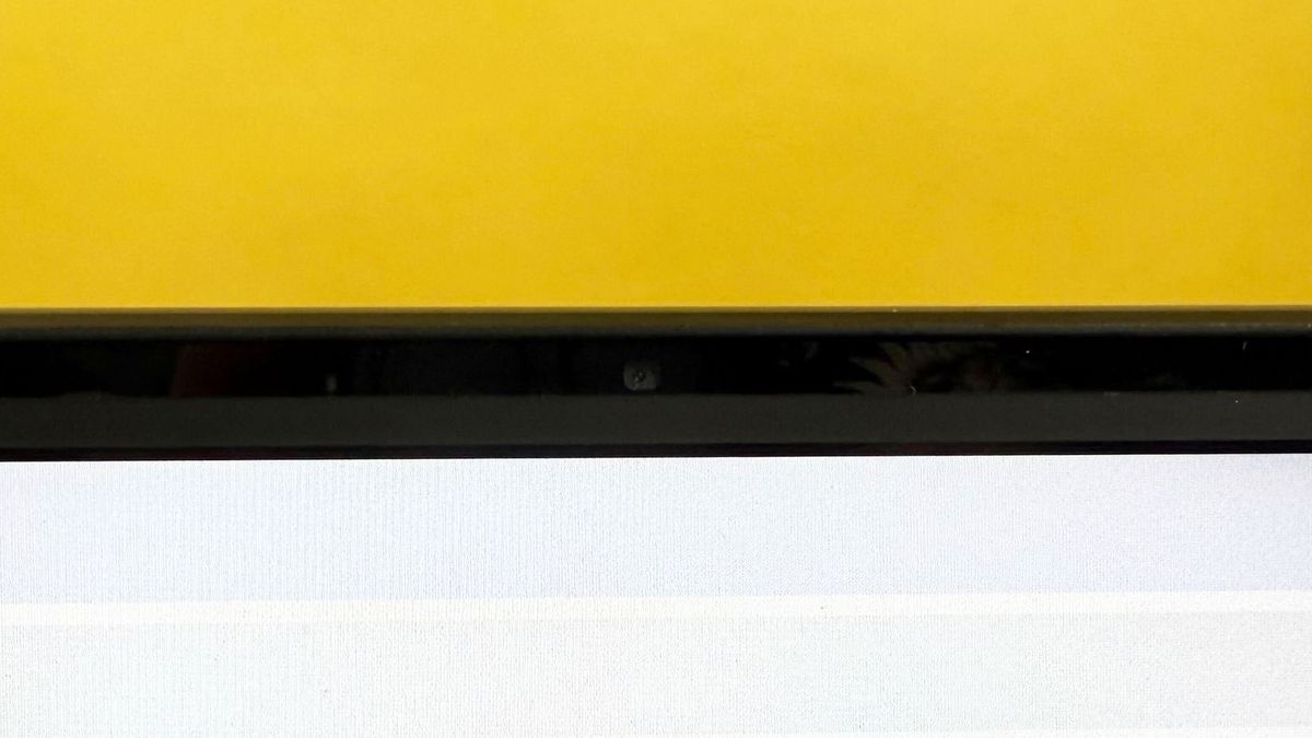 HP ZBook Studio 16 G11 mobile workstation on a white desk with a black table mat, against a yellow backdrop.