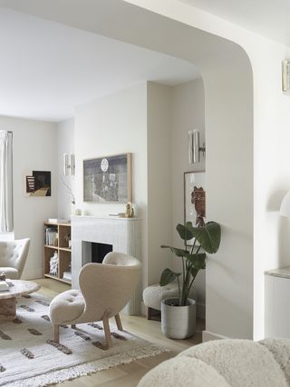 white living room with curved arch and white armchairs