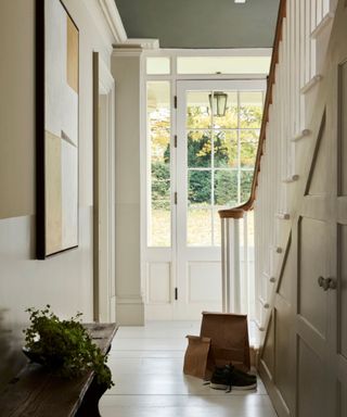 entryway with light neutral color scheme, white wooden flooring