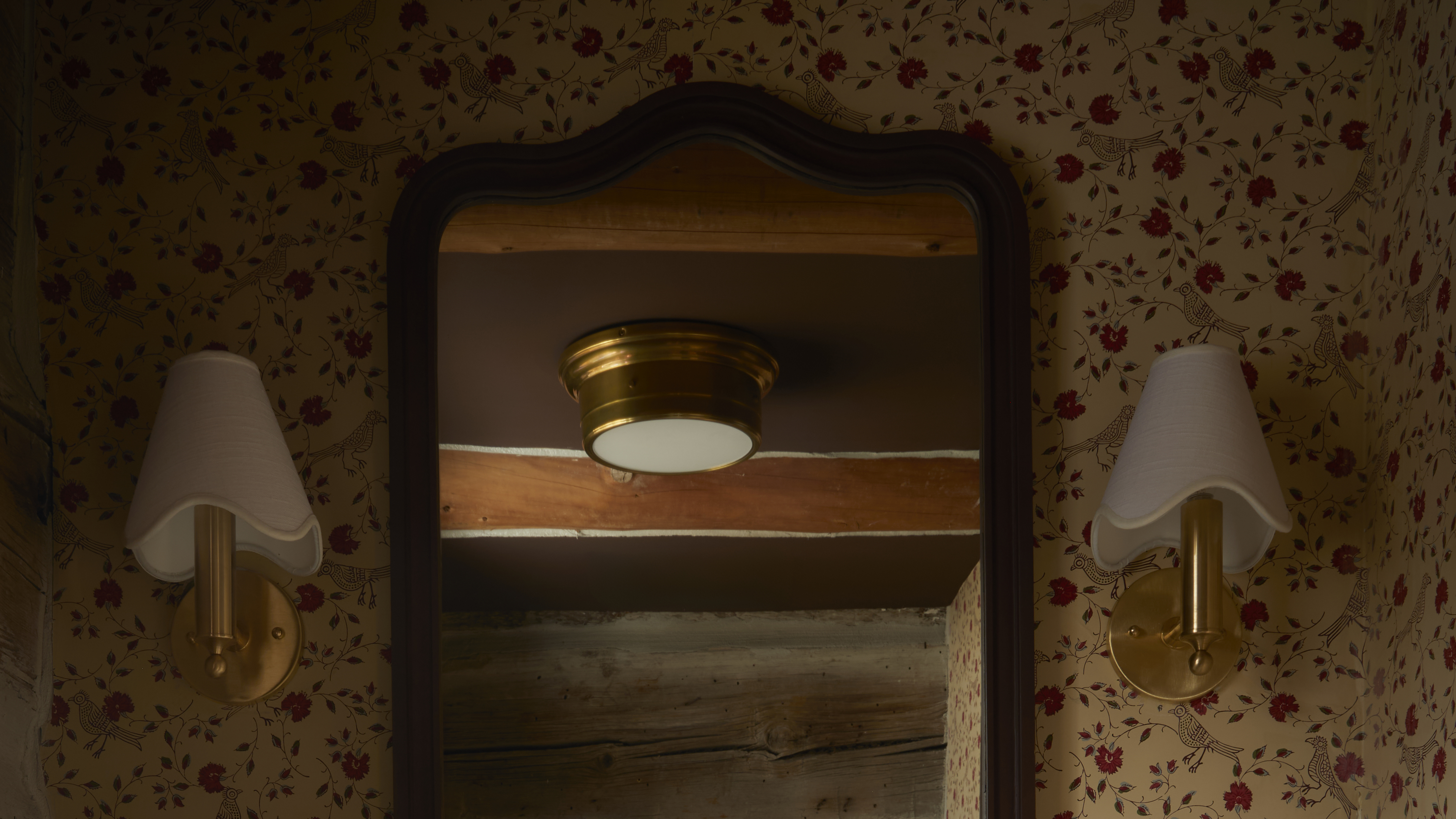 powder room with floral wallpaper on the wall behind a mirror