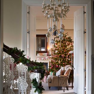 view through from traditional hallways decorated for christmas to sitting room with tree