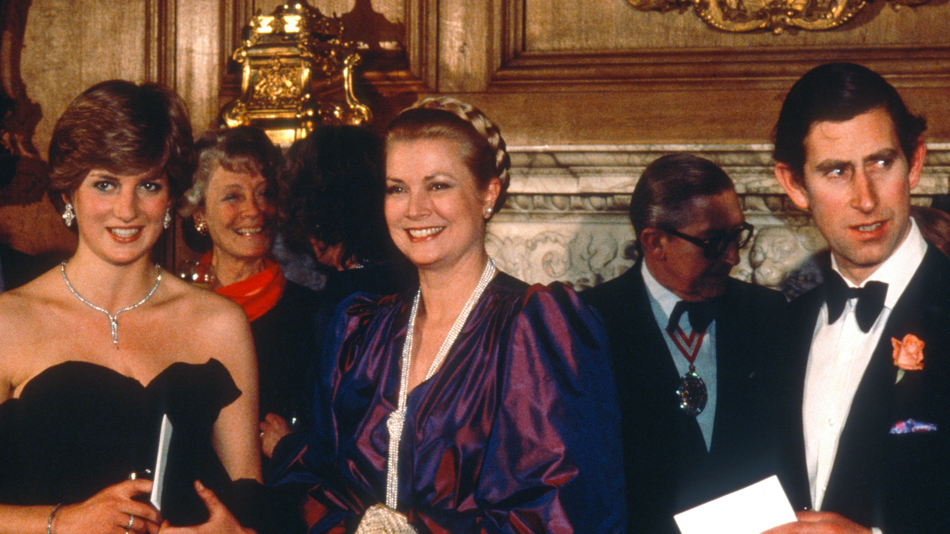 Princess Diana wears a strapless black taffeta Emanuel dress and poses next to Princess Grace Kelly of Monaco and King Charles on March 9, 1981 in London, United Kingdom