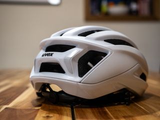 A white Uvex Surge helmet stands on a wooden table