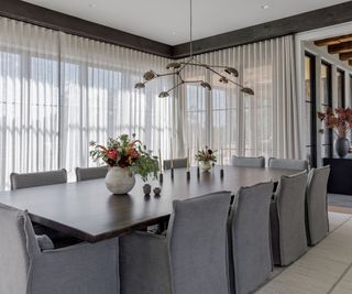 Dining room with wrap around windows with white drapes