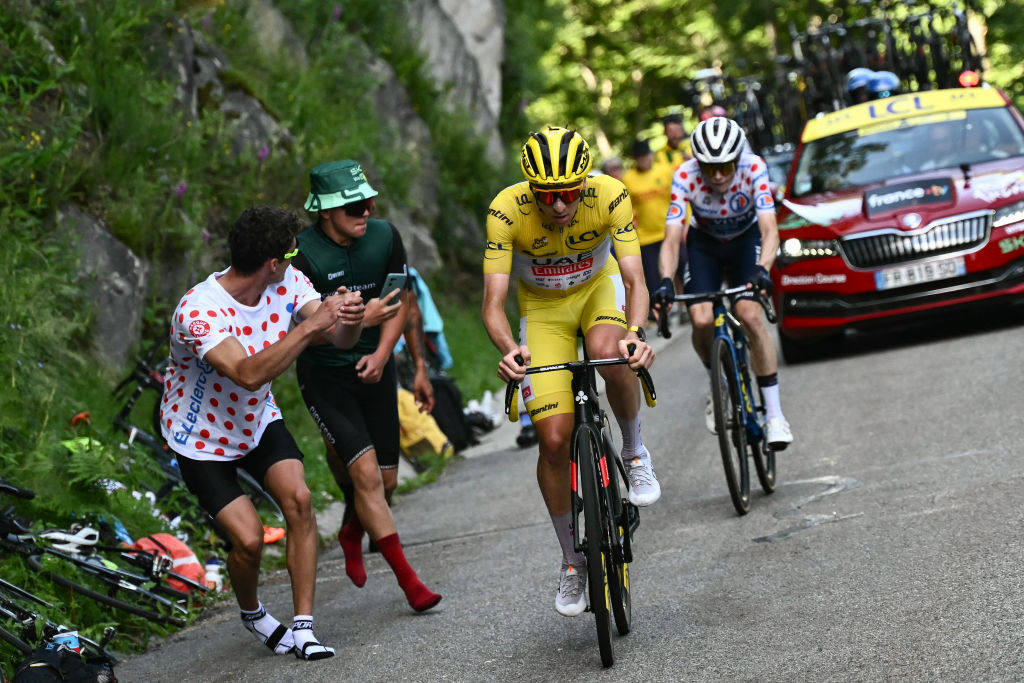 UAE Team Emirates team's Slovenian rider Tadej Pogacar wearing the overall leader's yellow jersey takes the lead as he cycles past Team Visma - Lease a Bike team's Danish rider Jonas Vingegaard in the final ascent of the Plateau de Beille during the 15th stage of the 111th edition of the Tour de France cycling race, 197,7 km between Loudenvielle and Plateau de Beille, in the Pyrenees mountains, southwestern France, on July 14, 2024. (Photo by Marco BERTORELLO / AFP)