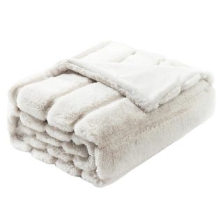 A fluffy faux fur throw folded into a square.
