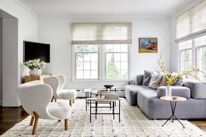 tv room with light walls and large, light grey sofa