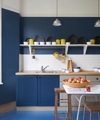 Blue kitchen with white shelving and yellow accents