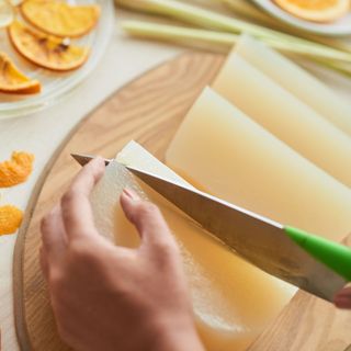 Hands of woman cutting soap base into small pieces for melting alamy 2GE2kY5