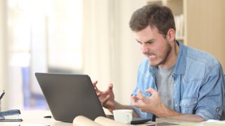 A man getting angry with his laptop.