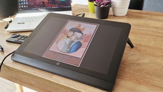 A shot of the XPPEN artist pro 16 (gen 2) tablet on a wooden table with a poster on the screen