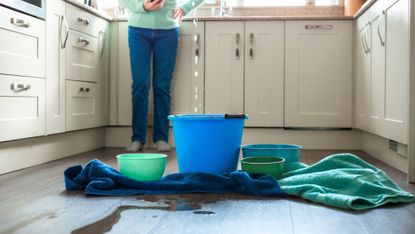 Worried home owner dealing with water leak in the kitchen 