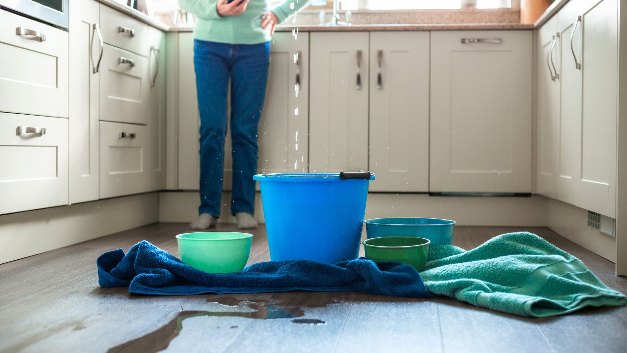 Worried home owner dealing with water leak in the kitchen 