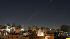 Missiles launched from Iran toward Israel are seen in the sky over the West Bank city of Hebron 