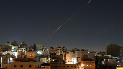 Missiles launched from Iran toward Israel are seen in the sky over the West Bank city of Hebron 