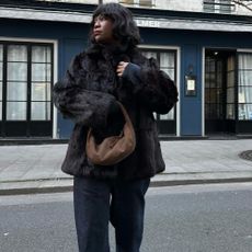 Influencer wears a brown suede bag.