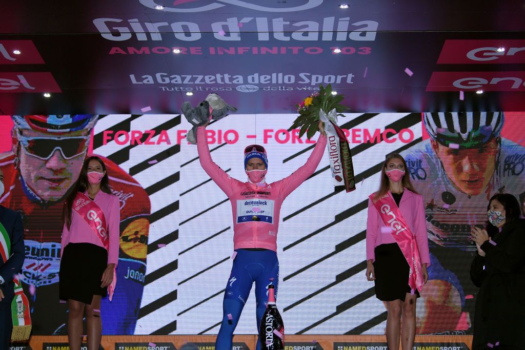 CAMIGLIATELLO SILANO ITALY OCTOBER 07 Podium Joao Almeida of Portugal and Team Deceuninck QuickStep Pink Leader Jersey Fabio Jakobsen of The Netherlands and Team Deceuninck QuickStep Celebration Mask Miss Hostess Covid safety measures Mascot Flowers ForzaFabio during the 103rd Giro dItalia 2020 Stage 5 a 225km stage from Mileto to Camigliatello Silano 1275m girodiitalia Giro on October 07 2020 in Camigliatello Silano Italy Photo by Tim de WaeleGetty Images