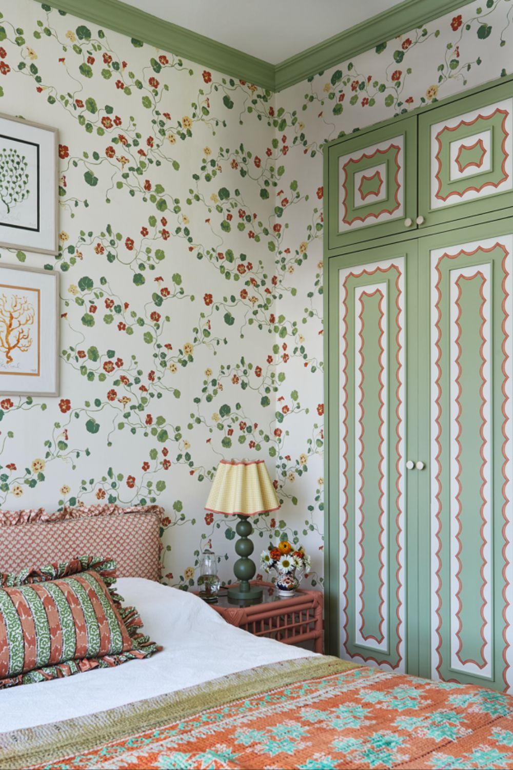 floral wallpapered bedroom with green painted closet and a orange and green bedscape