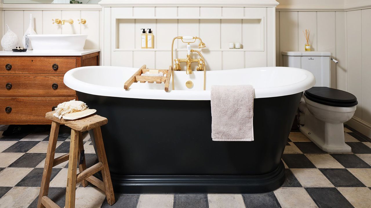 Bathroom with checkerboard flooring and black freestanding bath