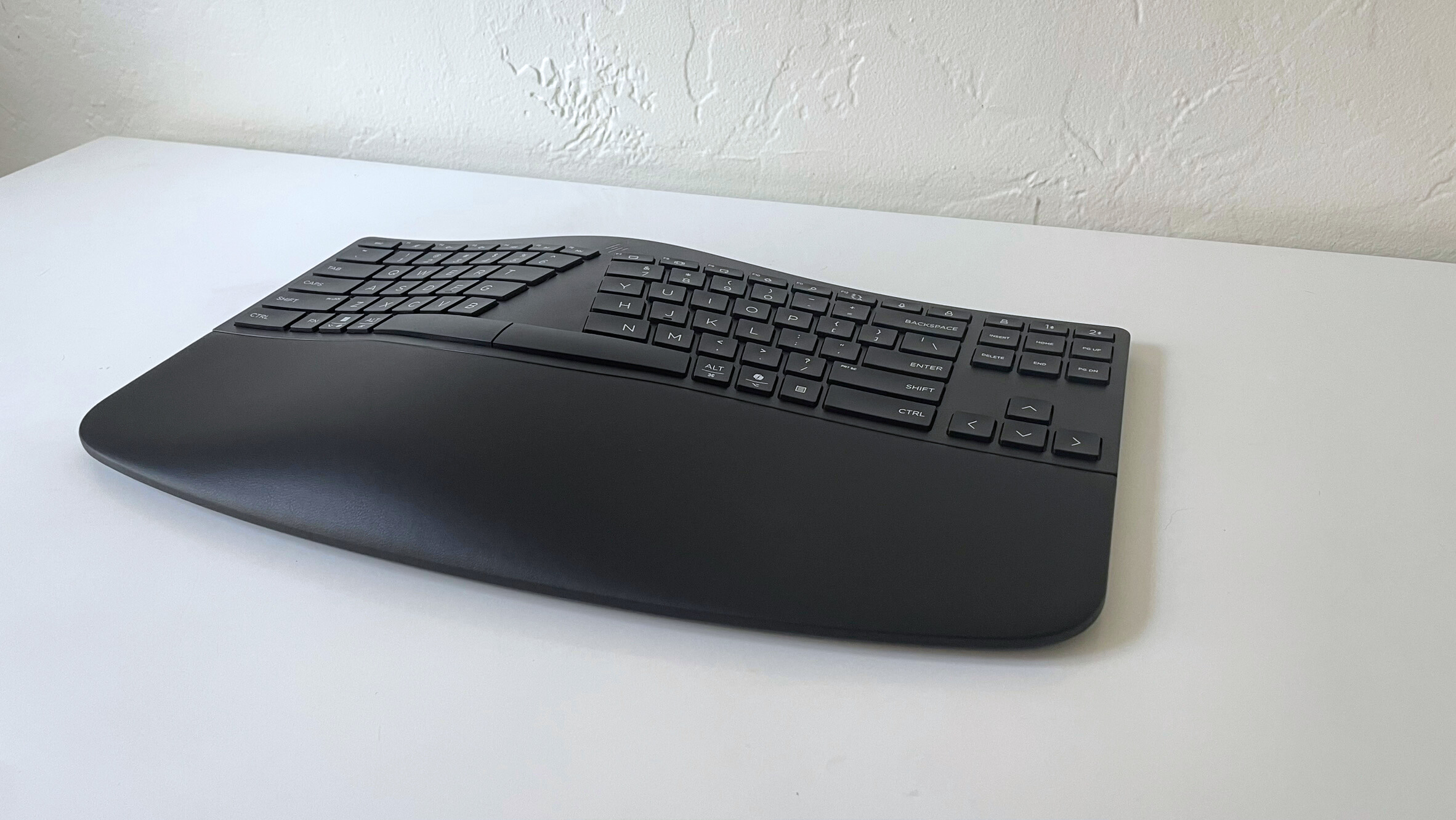 El teclado ergonómico HP 960 sobre un escritorio blanco visto desde un lado