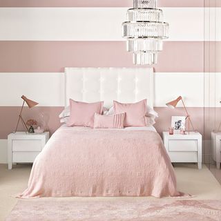 bedroom with pink and white wall and double bed with bedside table