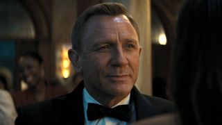 Daniel Craig smiling in a tux at Ana de Armas in No Time to Die. 