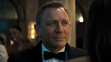 Daniel Craig smiling in a tux at Ana de Armas in No Time to Die. 