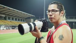 Photographer James Artaius using the Sony A9 III with Sony 300mm lens, standing in a floodlit track and field stadium at night