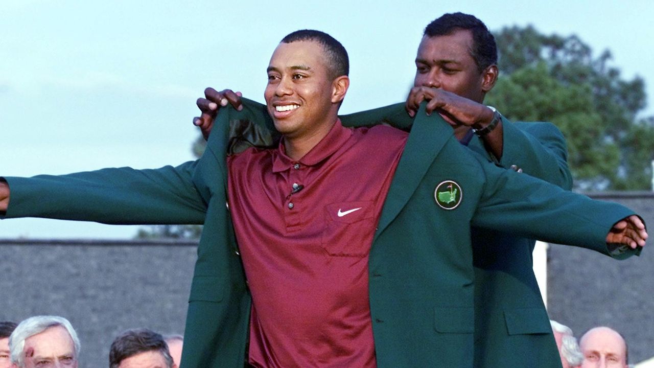 Tiger Woods receives the Green Jacket from Vijay Singh after the 2001 Masters