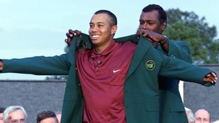 Tiger Woods receives the Green Jacket from Vijay Singh after the 2001 Masters