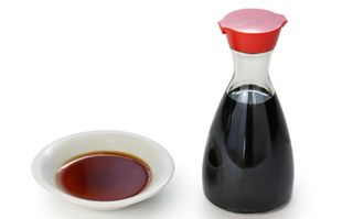 a bottle of soy sauce with a dipping dish