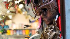 A collection of steampunk masks are seen on display at a market.