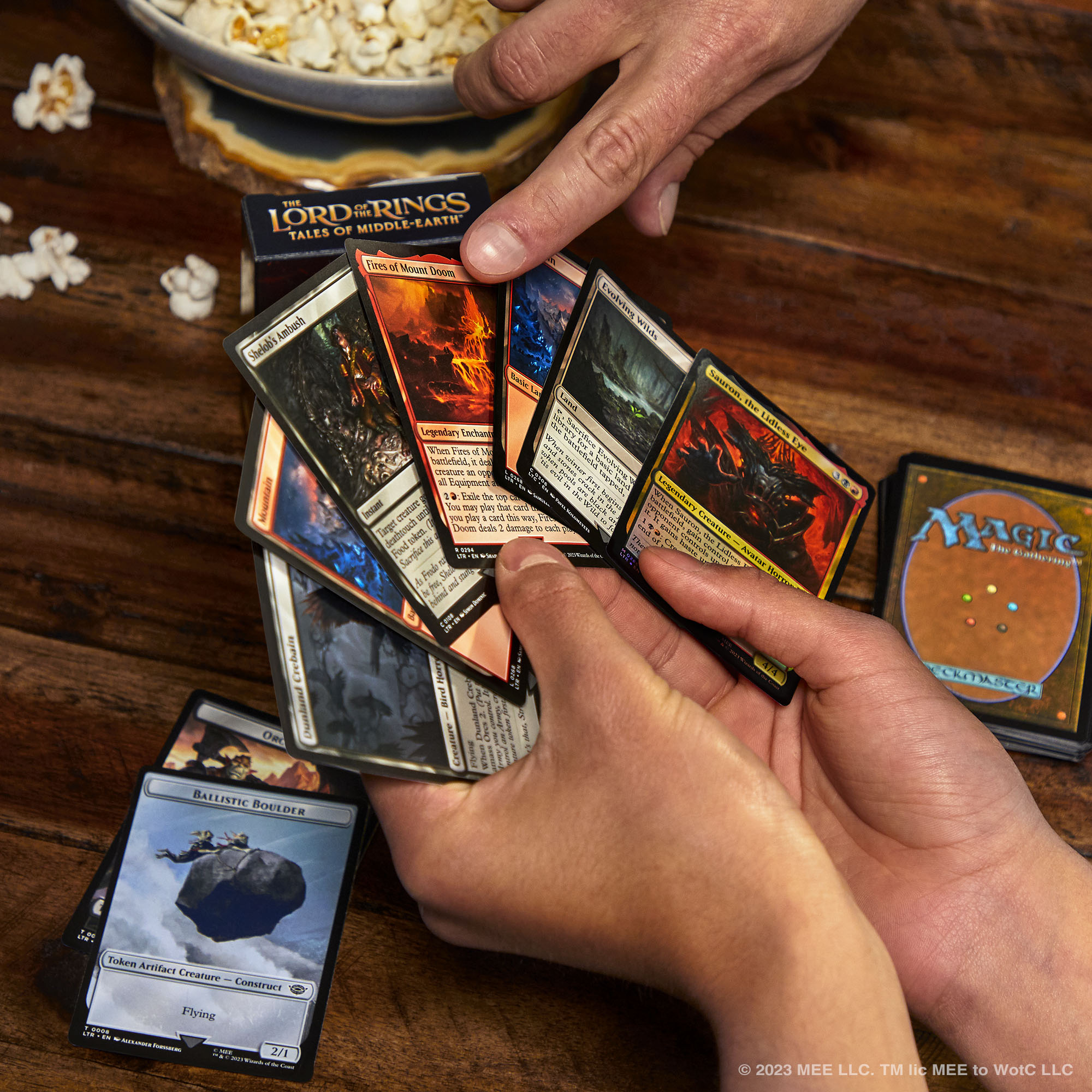 Magic: The Gathering players hold a deck of the cards while playing on a tabletop.