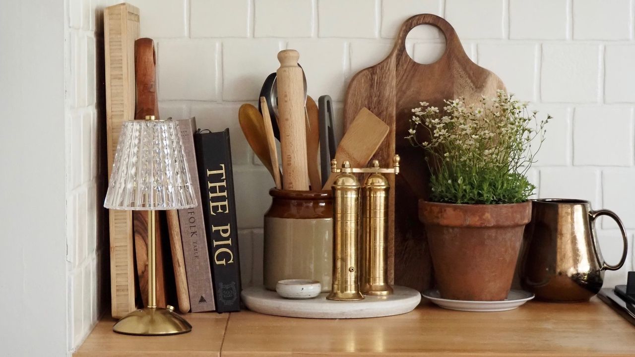 Kitchen counter with a wireless table lamp, books and kitchen utensils