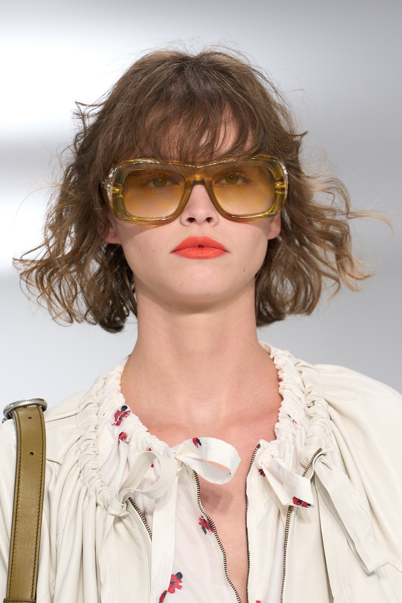 Burberry show model with big sunglasses red lips and a boho bob