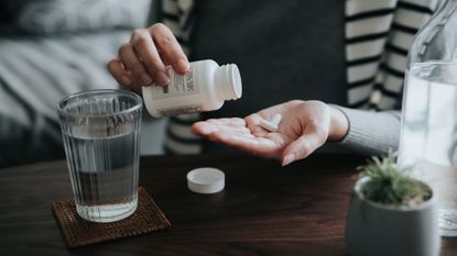 woman taking a dietary supplement with water
