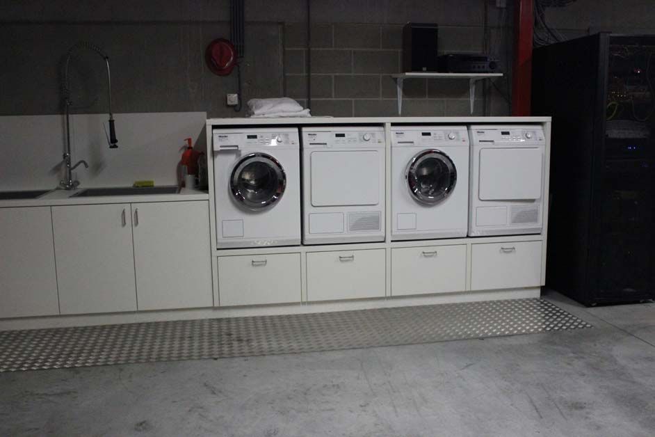 Two washers and dryers sit at the back of the service course