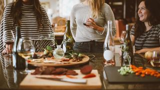 women standing around table getting ready to grill