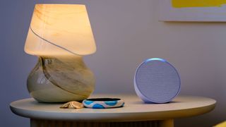 Amazon Echo Pop Bluetooth speaker on a night table.