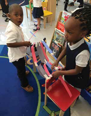 PreK-3 to fifth graders at Amidon-Bowen take on the paper bridge challenge using paper, masking tape, and scissors. 