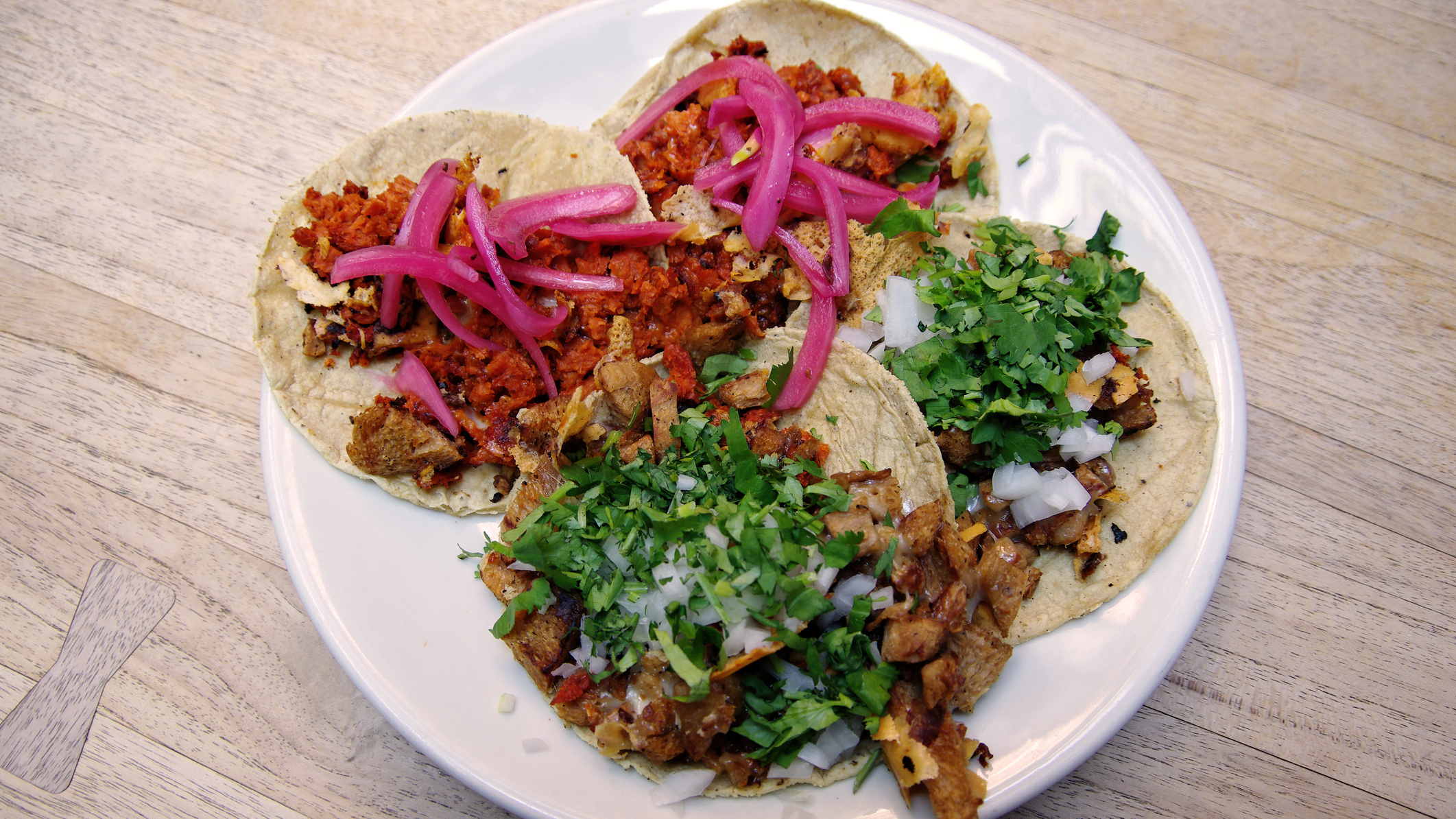Four soft-shell tacos on a plate