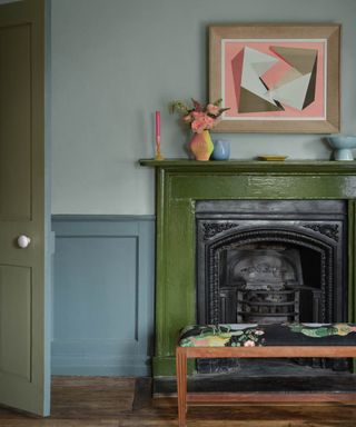 living room with blue walls, green gloss fireplace, neon pink artwork