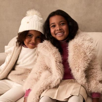 Two girls wearing pale pink winter outfits