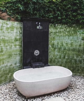 outdoor bath with wall-mounted shower and green painted wall