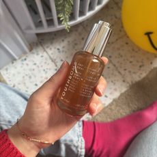 Mica Ricketts holding bottle of Beauty Pie Youthbomb 360° Radiance Concentrate Serum 