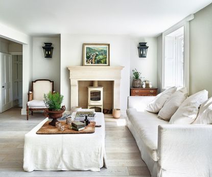 White armchair, white sofa and cushions, stone fireplace