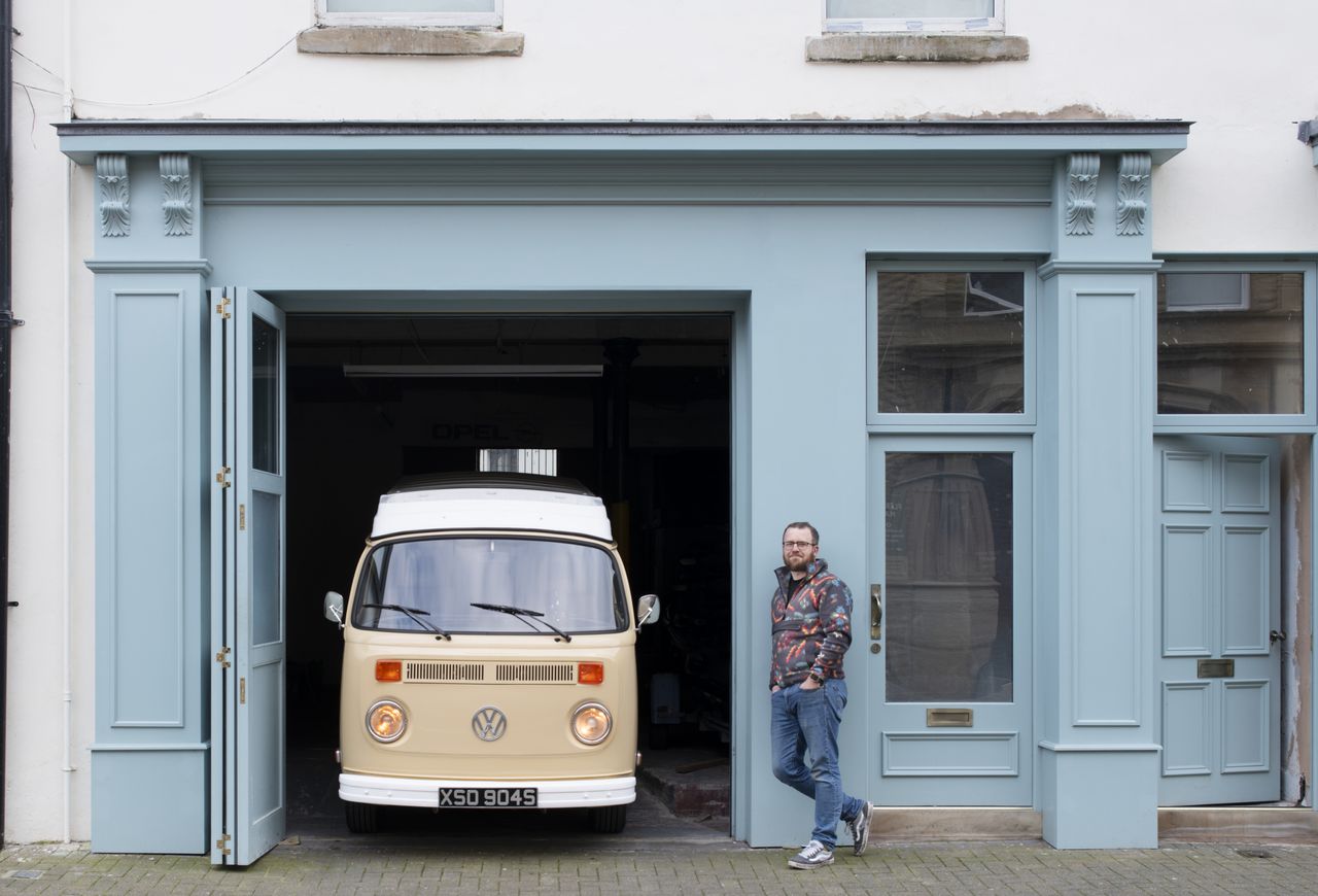 A man stands outside a restored shopfront in Fleetwood